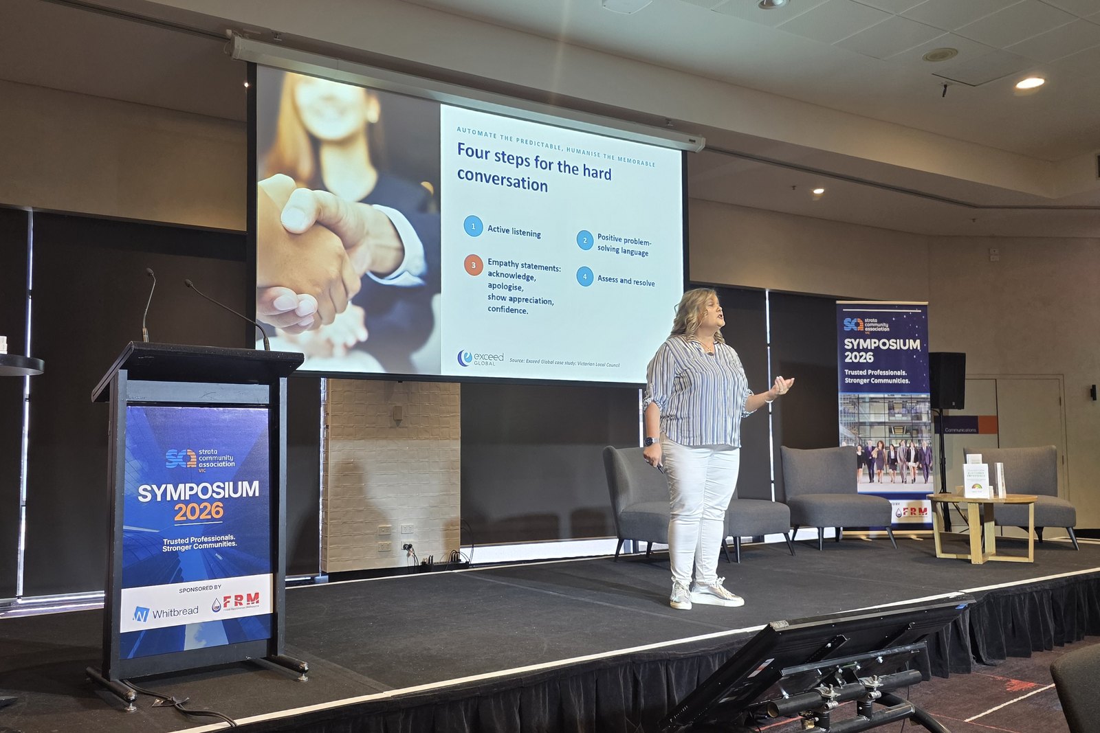 Isabella Villani on stage at the SCA (Vic) Symposium 2026 beside a slide titled Four steps for the hard conversation